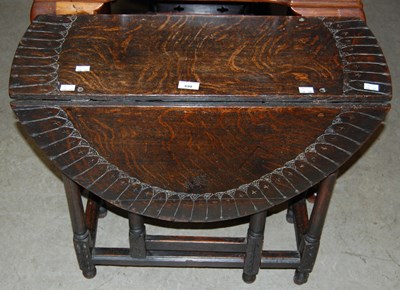 Lot 699 - A stained oak drop-leaf gate leg table with...
