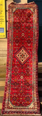 Lot 924 - A Persian runner, the madder ground centred...