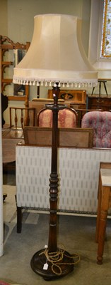 Lot 769 - A 20th century mahogany floor lamp with cream...