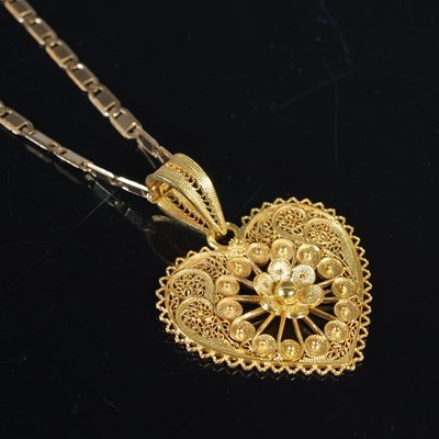 Lot 128 - A yellow metal necklace suspending a yellow...