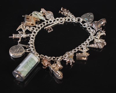 Lot 151 - A vintage silver charm bracelet suspending...
