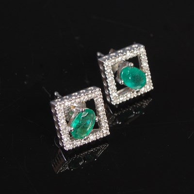 Lot 250 - A pair of white metal emerald and diamond...
