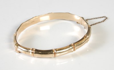 Lot 311 - A 9ct gold hinged bangle simulating bamboo, 10g.