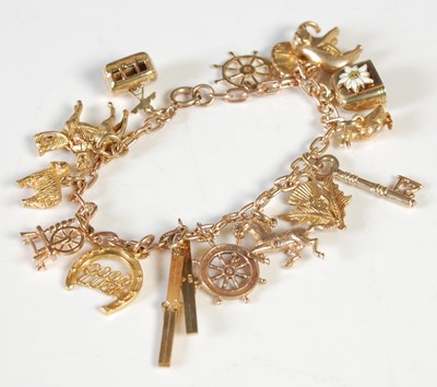Lot 184 - A 9ct gold charm bracelet suspending fifteen...