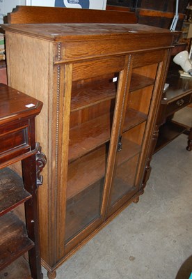 Lot 731 - An early 20th century oak glazed two-door...