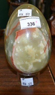 Lot 336 - A green onyx stone egg raised on a circular...