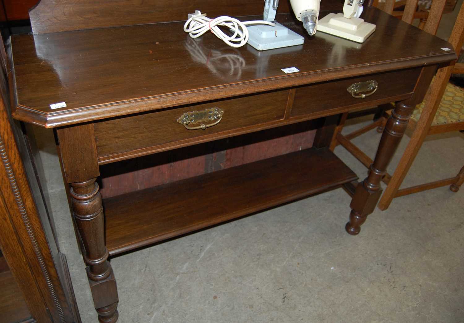 Lot 733 - A dark wood console table with raised gallery...