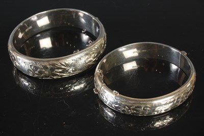 Lot 61 - Two hinged silver bangles, both with engraved...