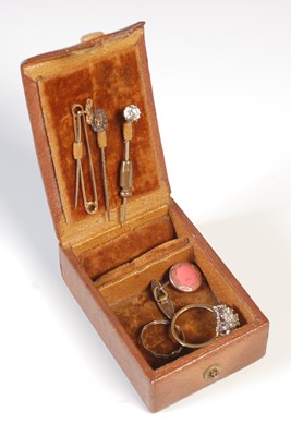 Lot 142 - A small brown leather jewellery box containing...