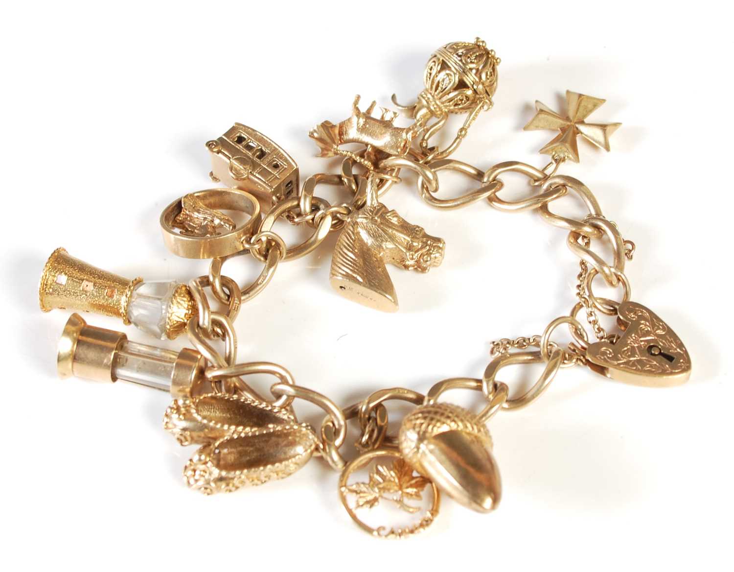 Lot 174 - A 9ct gold charm bracelet suspending 11...