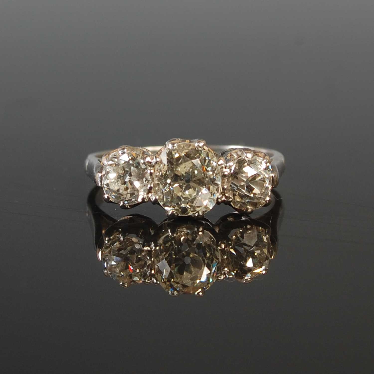 Lot 189 - A white metal three stone diamond ring,...