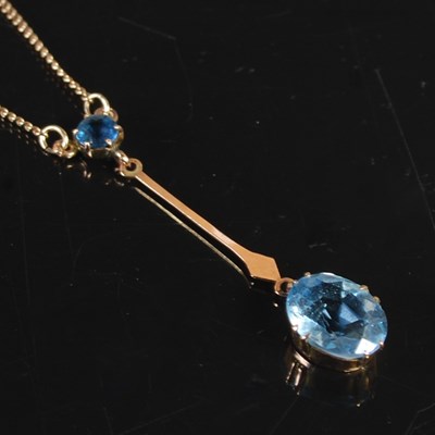 Lot 210 - A yellow metal and blue gemstone set pendant...