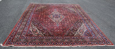 Lot 804 - An Iranian madder ground rug, 20th century,...