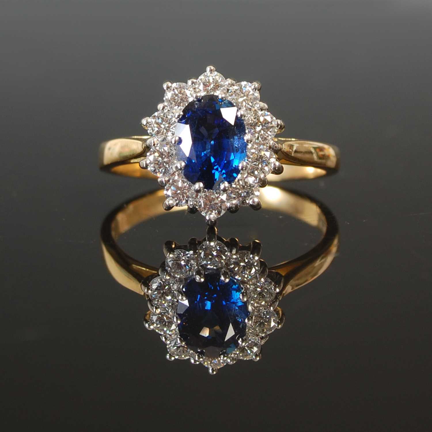 Lot 263 - An 18ct gold sapphire and diamond cluster ring,...