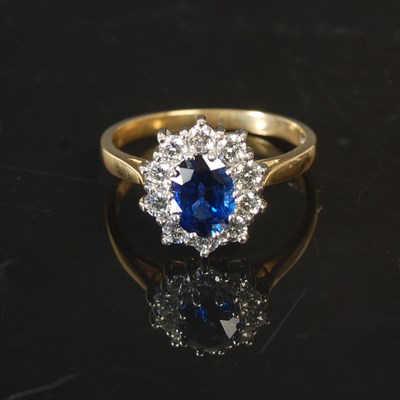 Lot 263 - An 18ct gold sapphire and diamond cluster ring,...