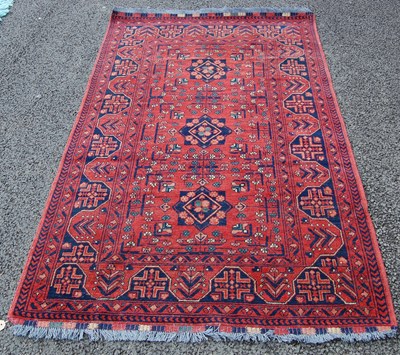 Lot 819 - A Persian rug, the madder ground centred with...
