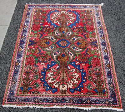 Lot 822 - A small Persian rug, the madder ground centred...