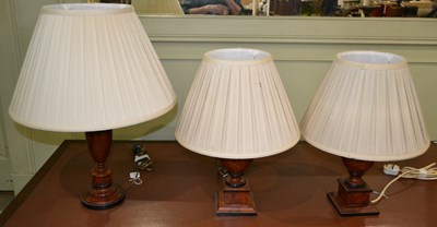 Lot 1055 - A group of three wooden table lamps, with a...