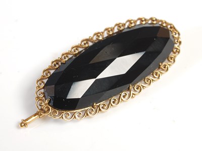 Lot 450 - An 18ct. gold and faceted jet oval brooch,...