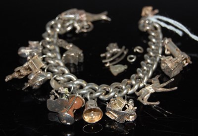 Lot 58 - A silver charm bracelet suspending various...