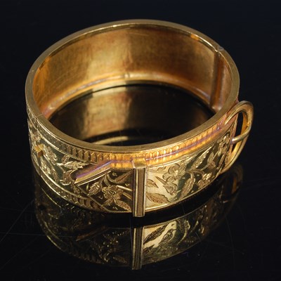 Lot 367 - A late 19th century yellow metal hinged bangle...