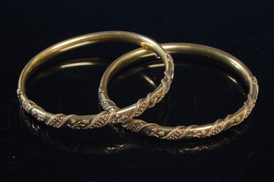 Lot 375 - A pair of yellow metal hinged bangles, both...
