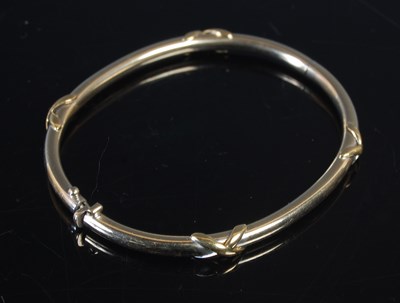 Lot 438 - A yellow metal hinged bangle, stamped '750',...