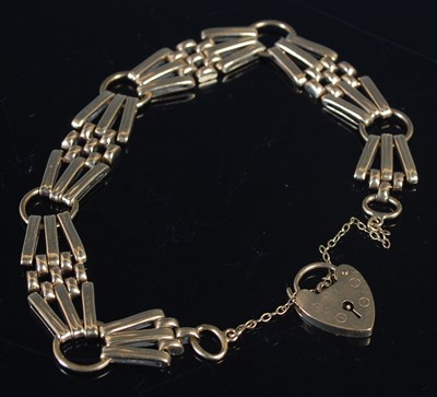 Lot 447 - A 9ct gold bracelet with heart shaped lock, 18....