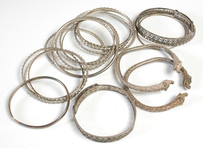 Lot 479 - A pair of Indian white metal bangles, with...