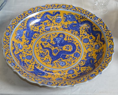Lot 740 - A Chinese porcelain yellow ground dragon dish,...