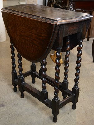 Lot 851 - An early 20th century oak drop leaf occasional...