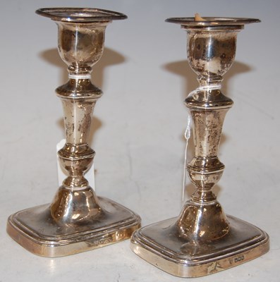 Lot 112 - A pair of George V silver candlesticks,...