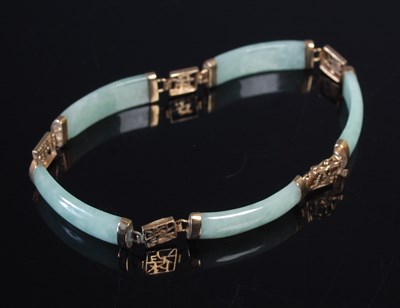 Lot 10 - A Chinese gold mounted green stone articulated...