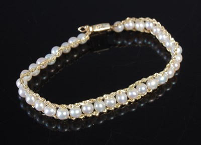 Lot 11 - A gold and pearl set bracelet, the clasp...