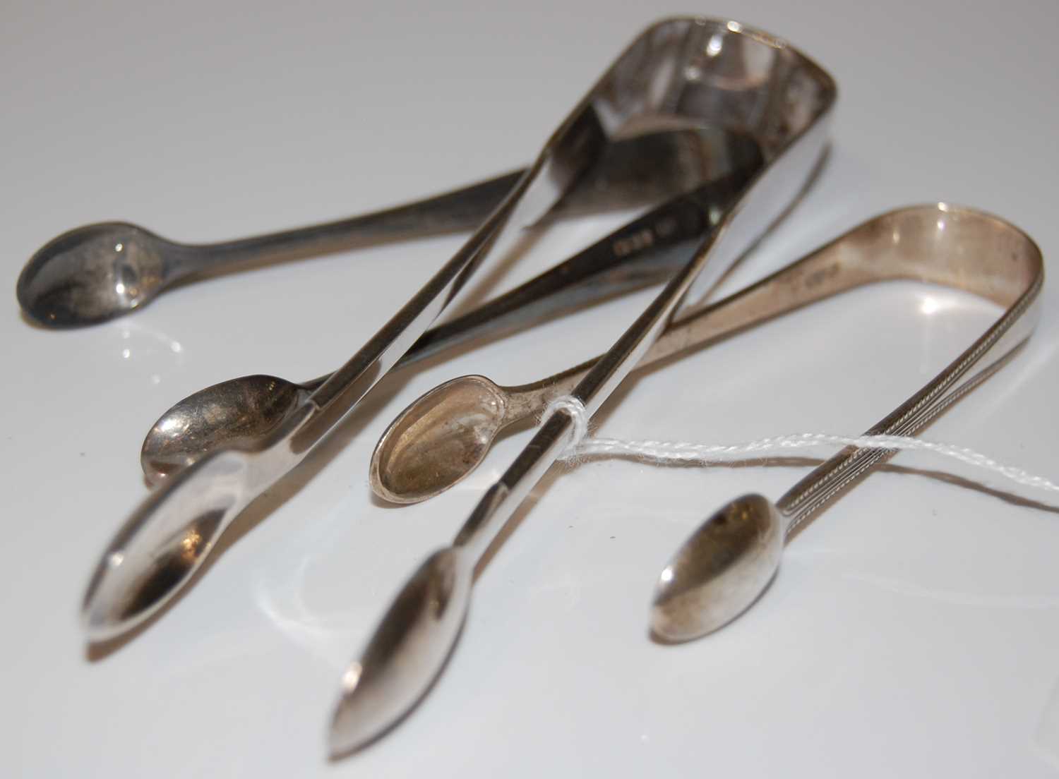 Lot 120 - Three pairs of assorted silver sugar tongs,...