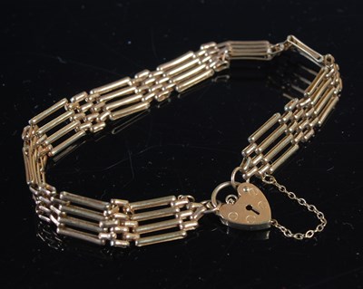 Lot 26 - A 9ct gold gatelink bracelet, with heart...