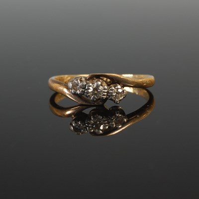 Lot 70 - A white and yellow metal three stone diamond...