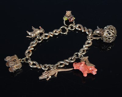 Lot 213 - A 9ct gold charm bracelet suspending six...