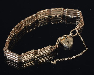 Lot 293 - A 9ct gold gatelink bracelet, with heart...