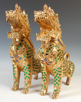 Lot 517 - A pair of jewelled giltwood foo / guardian...