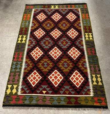Lot 929 - A Maimana Kilim rug, worked in burgundy, black,...