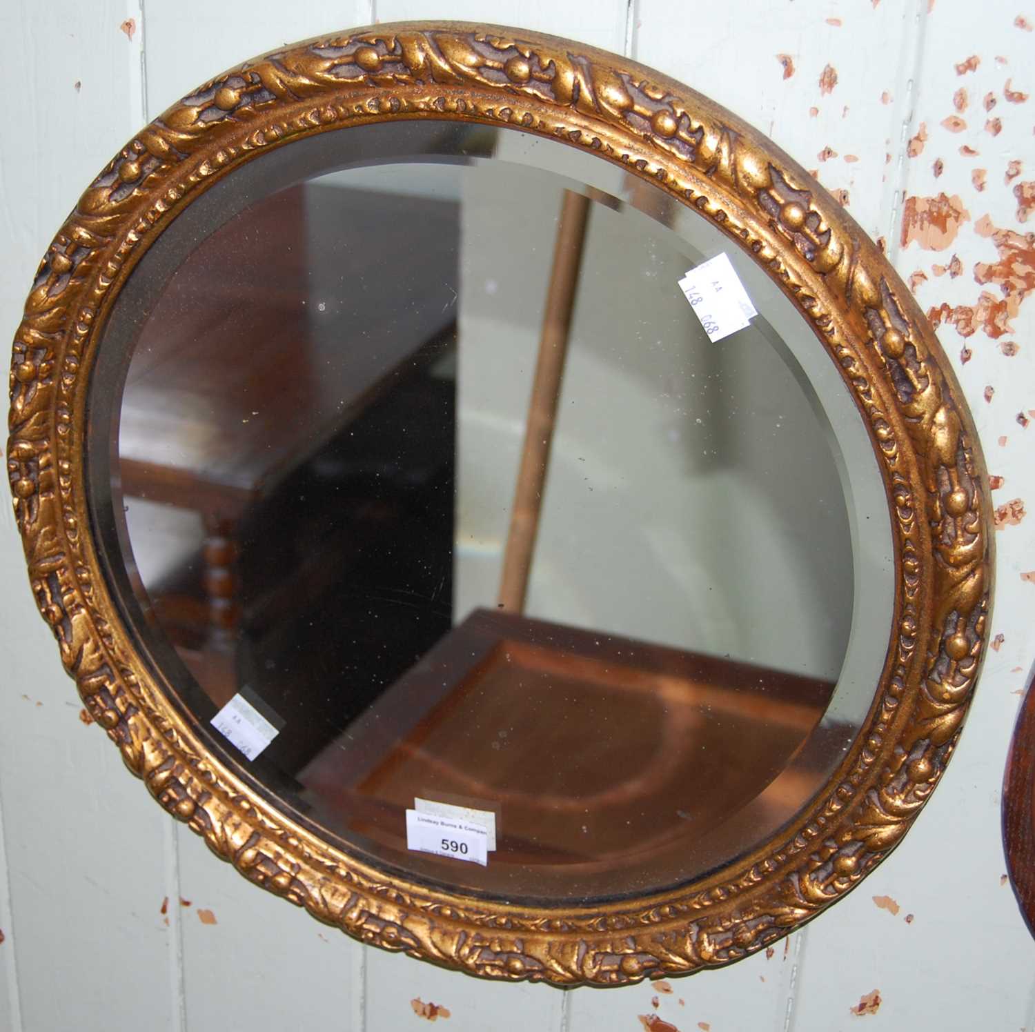 Lot 590 - A gold coloured circular wall mirror with...