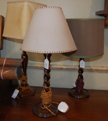Lot 597 - A near pair of wooden table lamps with barley...