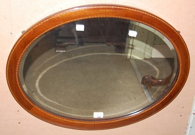 Lot 586 - An Edwardian oval bevelled wall mirror with...
