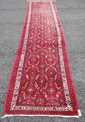 Lot 810 - A Persian runner, the madder ground decorated...