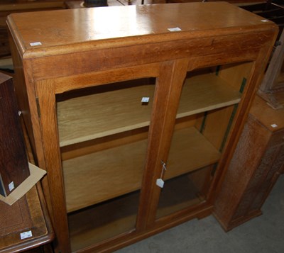 Lot 667 - An Art Deco oak two door display cabinet
