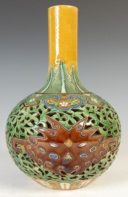 Lot 688 - A Chinese porcelain sancai glazed reticulated double-wall bottle vase, Qing Dynasty