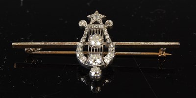 Lot 520 - An early 20th century white and yellow metal diamond set lyre-shaped bar brooch