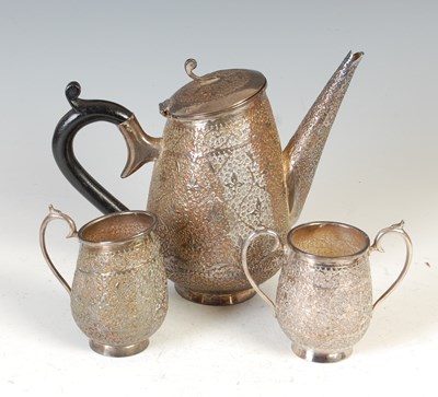 Lot 434 - A late 19th / early 20th century Indian white metal three-piece tea set