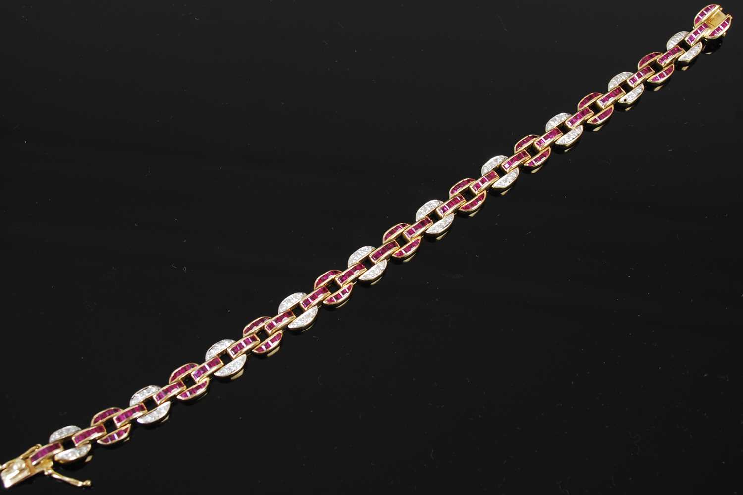 Lot 527 - A 20th century Art Deco style yellow metal, ruby and diamond set bracelet